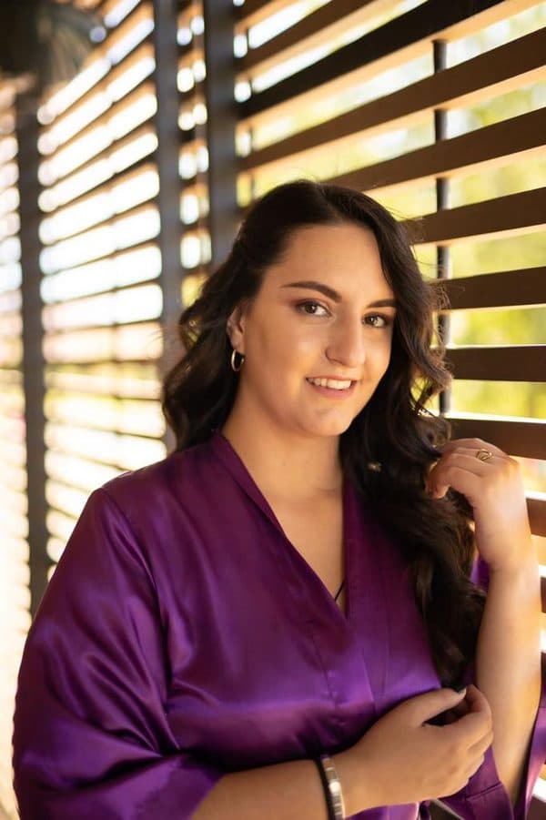 Client in a purple robe after hair and makeup