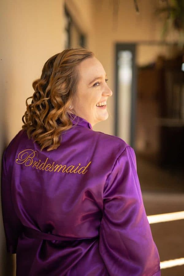 Bridesmaid with an upstyle in a purple robe
